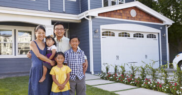 Portrait Of Family Standing Outside House