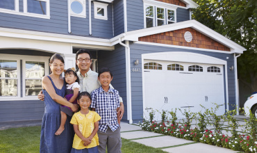 Portrait Of Family Standing Outside House