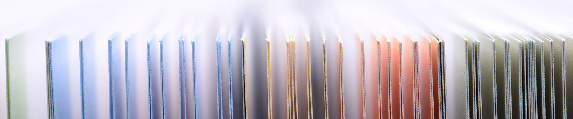 Row of colorful file folders or binders organized vertically in an office filing system.