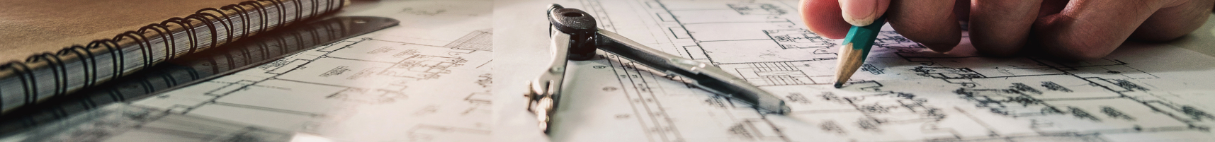 Close-up of a person drawing technical plans with a pencil and compass on architectural blueprints.